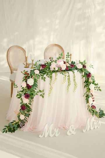 a table with flowers and greenery on it