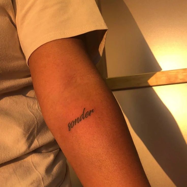 a person with a tattoo on their arm that reads sandler in cursive writing