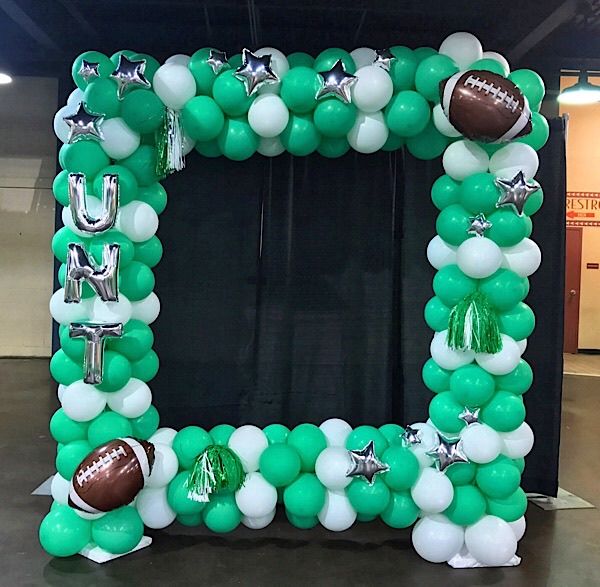 an inflatable balloon frame with footballs and stars