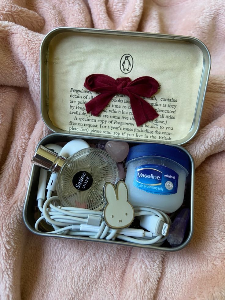 an open tin box with various items inside