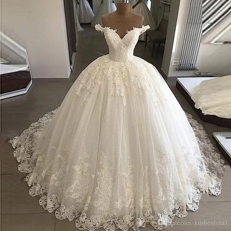 a white wedding dress on display in front of a mirror