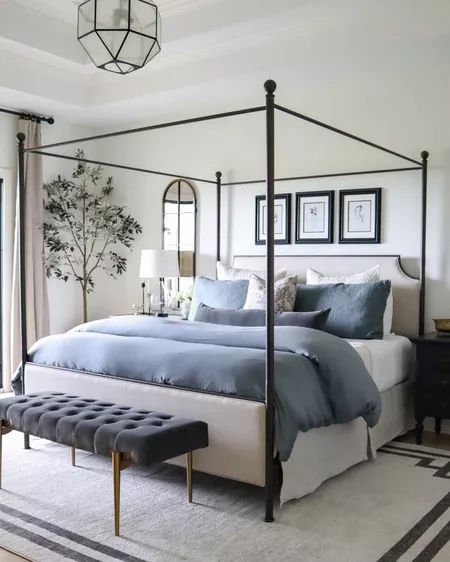 a bedroom with a four poster bed and blue comforter on top of the bed