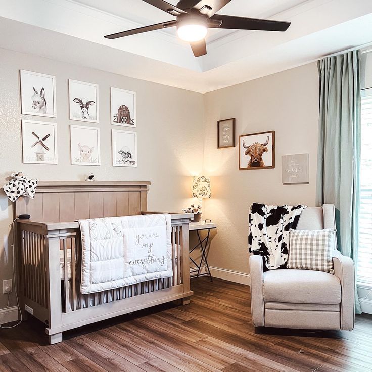 a baby's room with a crib, chair and pictures on the wall