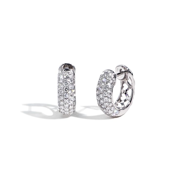 A stylish pair of huggie earrings showcasing 1.14ctw pav diamonds going down the front half of the hoop, designed with small hearts on the back. Beautifully crafted in 18K white gold. Luxury Diamond Hoop Earrings With Pave Setting, Luxury Huggie Earrings With Pave Setting In Cubic Zirconia, Luxury Huggie Hoop Earrings With Pave Setting, Luxury Diamond Huggie Earrings With Pave Setting, Luxury Diamond White Hoop Earrings With Pave Setting, Luxury Diamond White Diamond Huggie Earrings, Luxury Pave Setting White Gold Huggie Earrings, Luxury Diamond Huggie Earrings In Diamond White, Luxury White Gold Huggie Earrings With Pave Setting