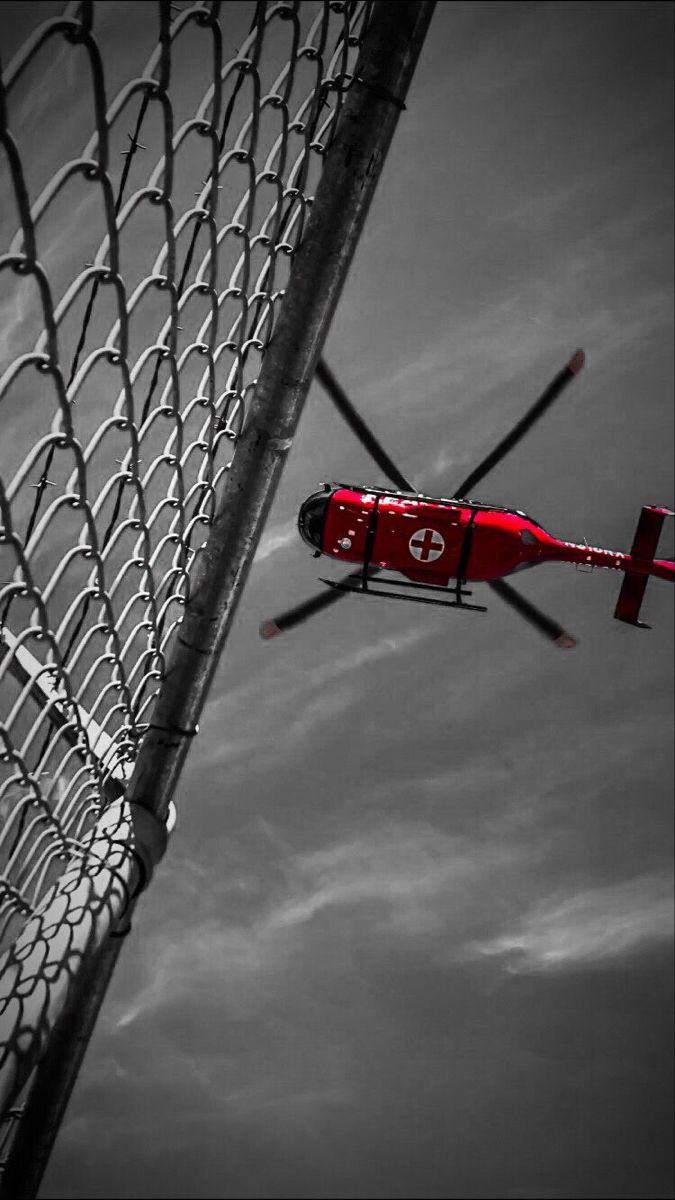 a red helicopter flying over a soccer goal