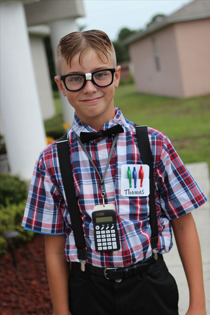 a young boy wearing glasses and suspenders with a cell phone in his hand while standing outside