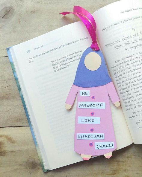 an open book with a paper doll hanging from it