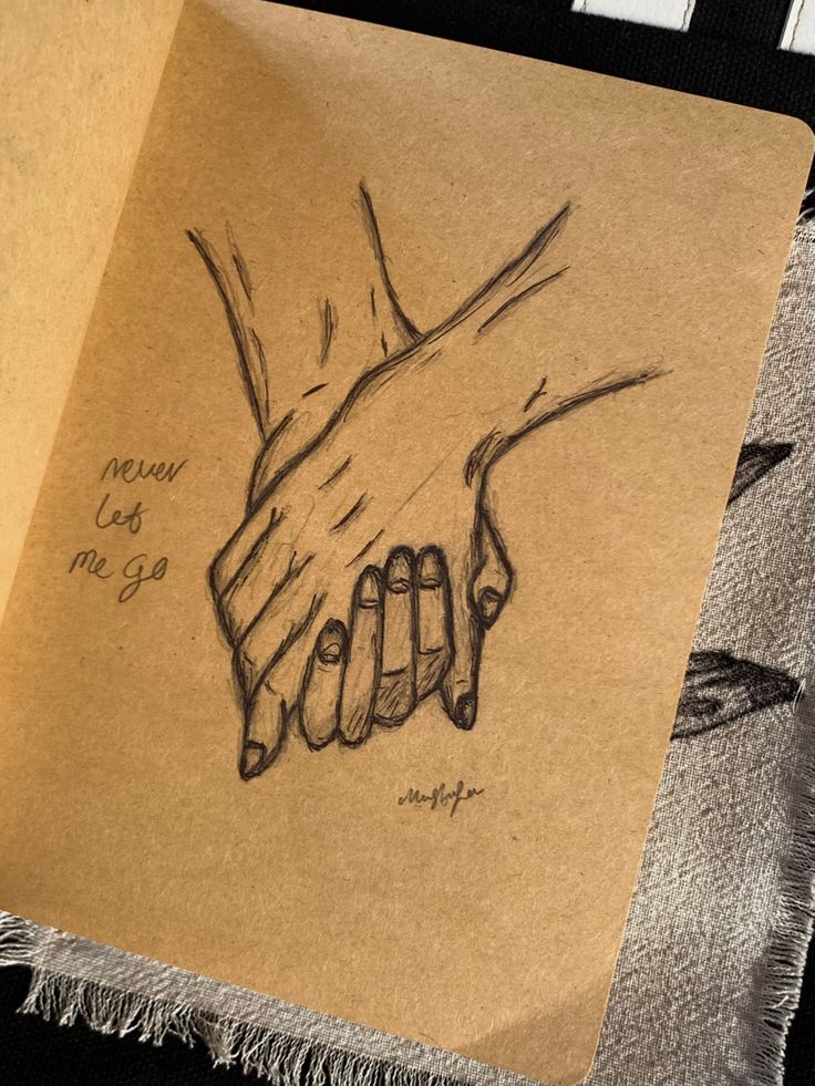 a piece of paper with a drawing of two hands holding each other's hand