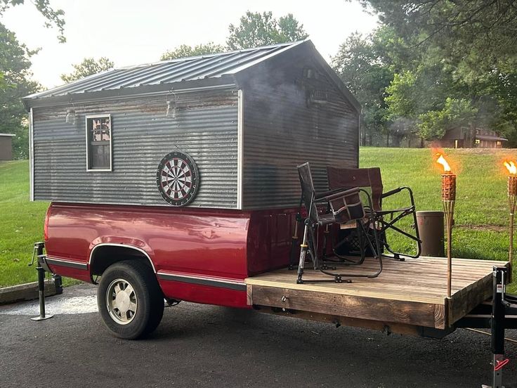 a red truck parked in front of a house with a dart on it's back