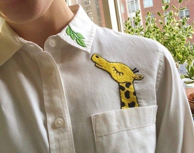 a person wearing a white shirt with a yellow giraffe embroidered on it