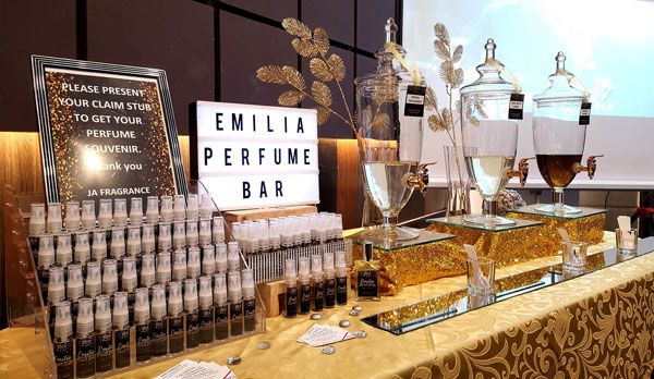 a table topped with lots of different types of bottles and glasses next to a projector screen