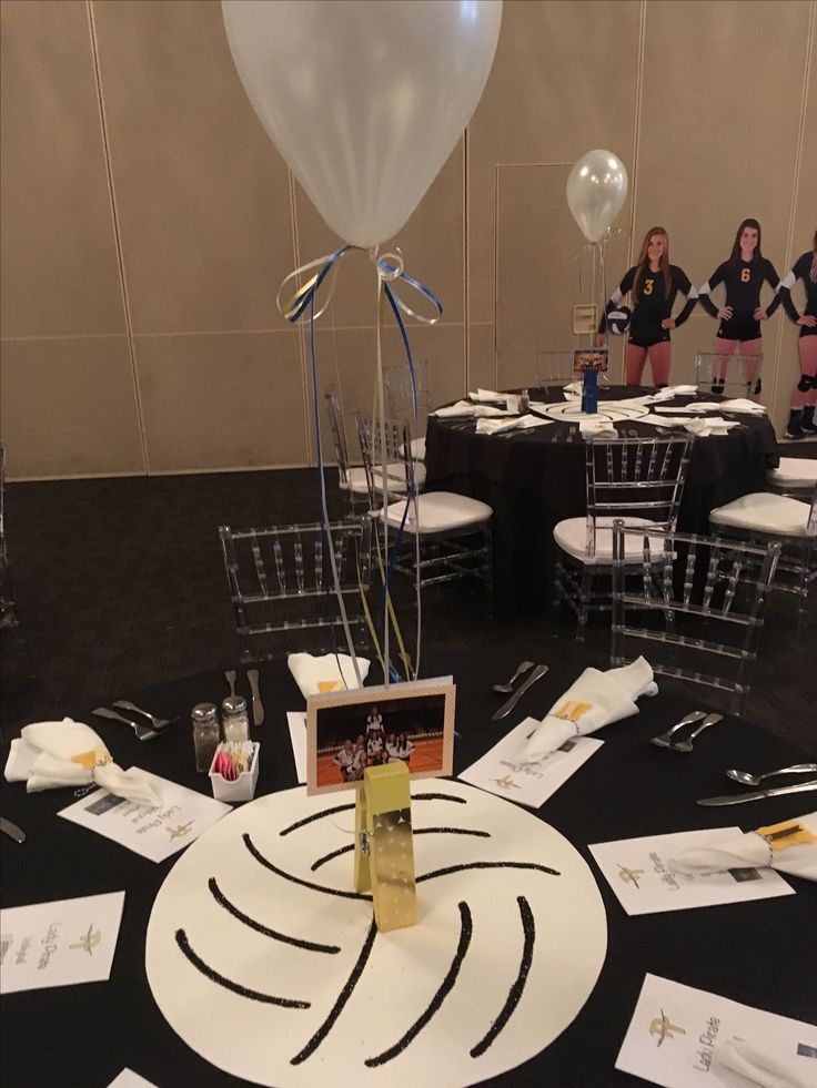 there is a table set up for a party with balloons and place cards on it