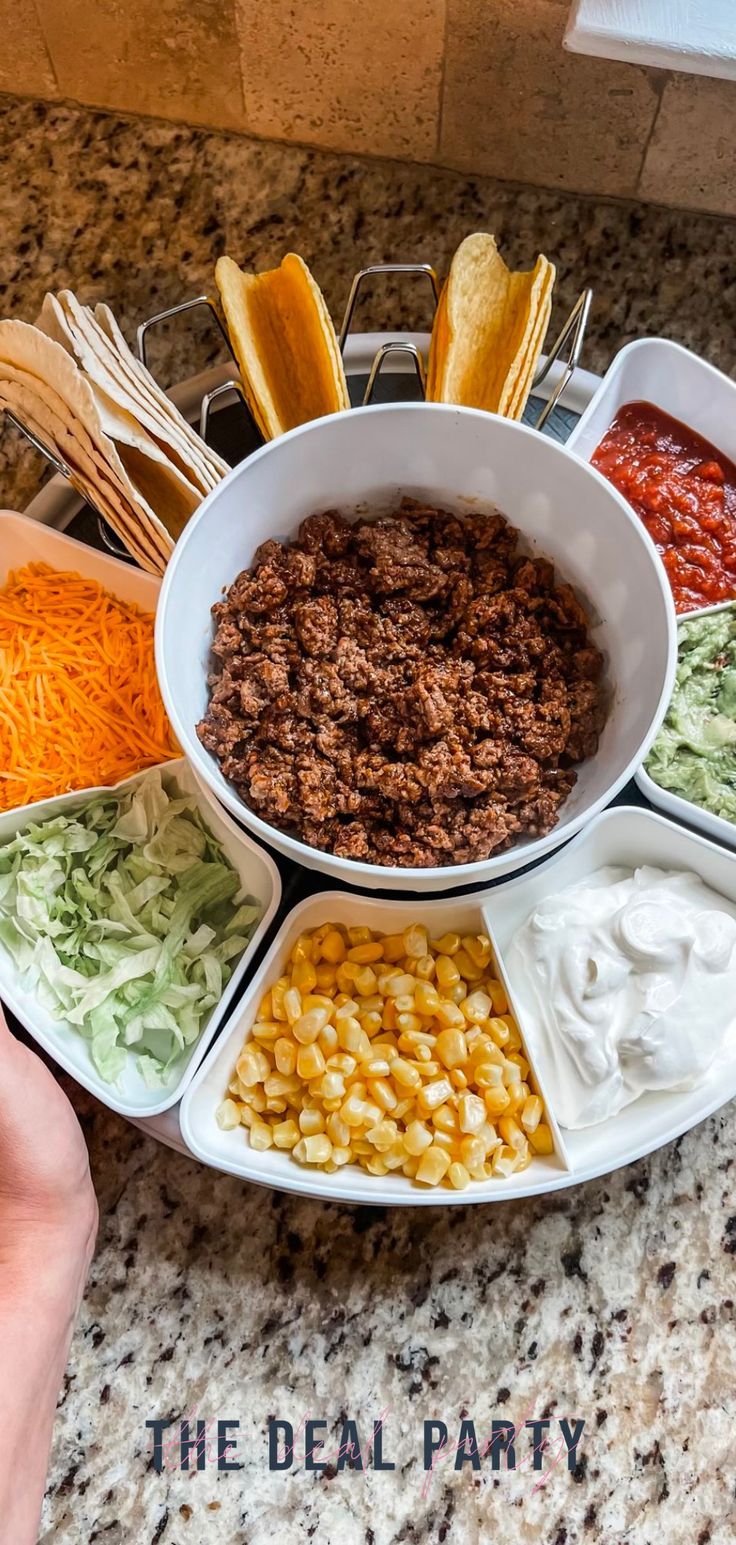 a bowl filled with different types of food on top of a counter next to chips