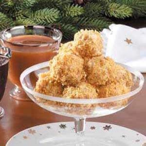 a glass bowl filled with fried food next to a cup of coffee and saucer