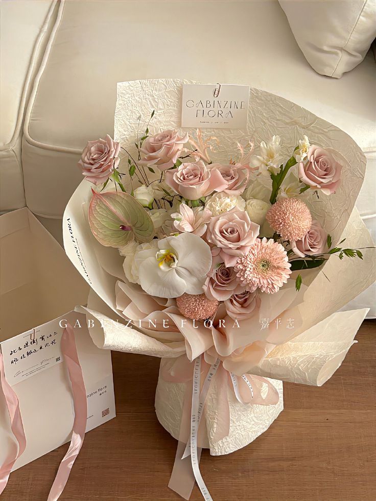 a bouquet of flowers sitting on top of a table next to a card and envelope