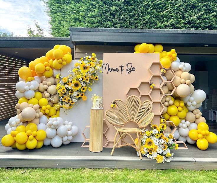 a display with balloons, flowers and honeycombs in the shape of bees on it