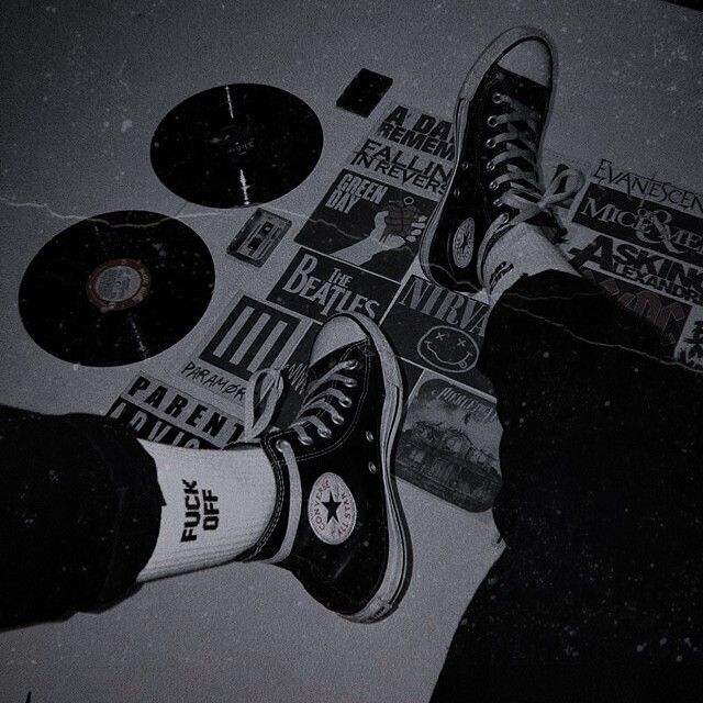 black and white photograph of someone's feet on the floor with various items around them