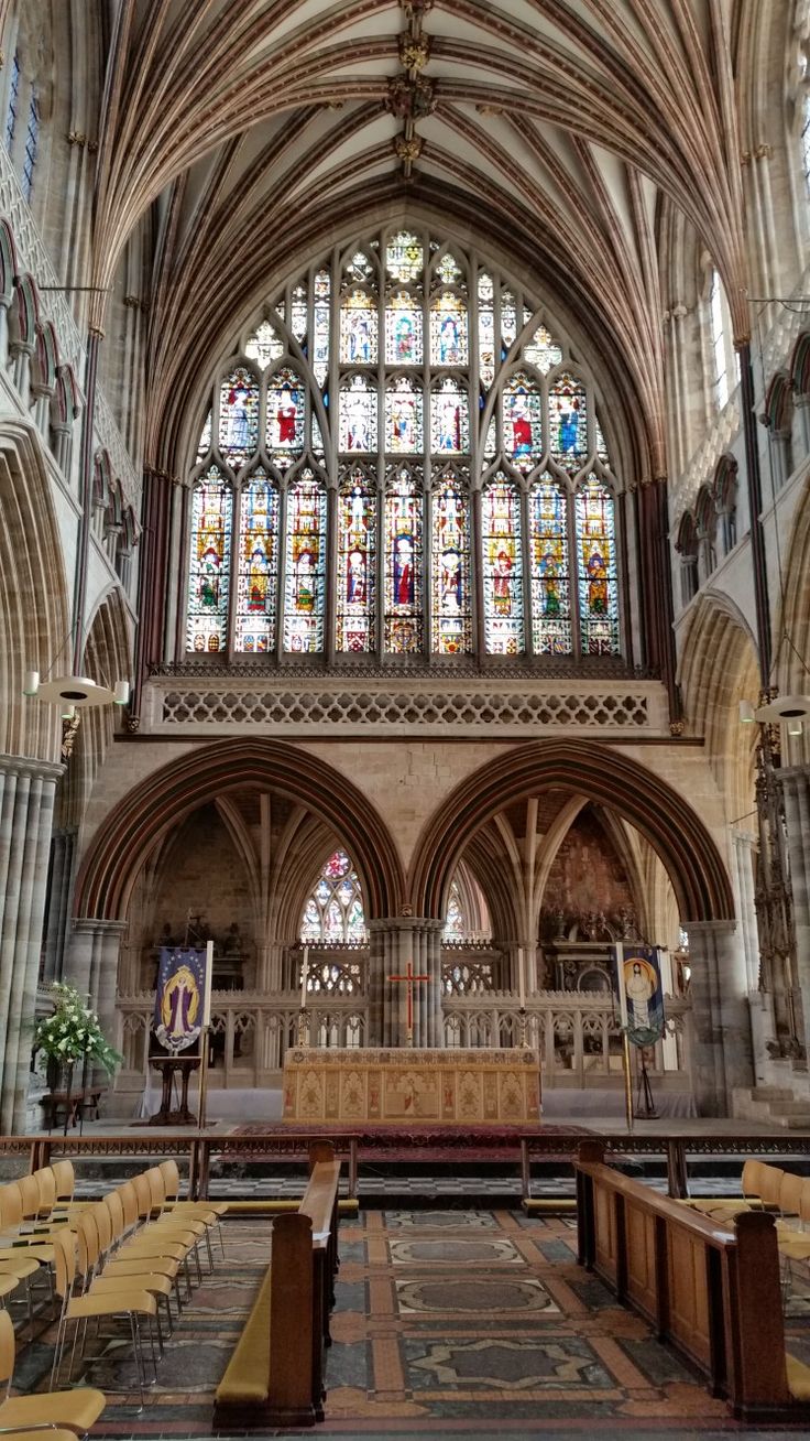 the inside of a large church with stained glass windows and pews in it's center