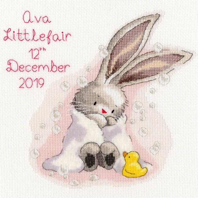 a cross stitch pattern with a bunny holding a rubber duckling in it's paws