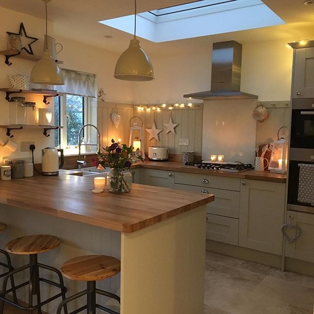 a large kitchen with an island counter top and wooden stools in front of it