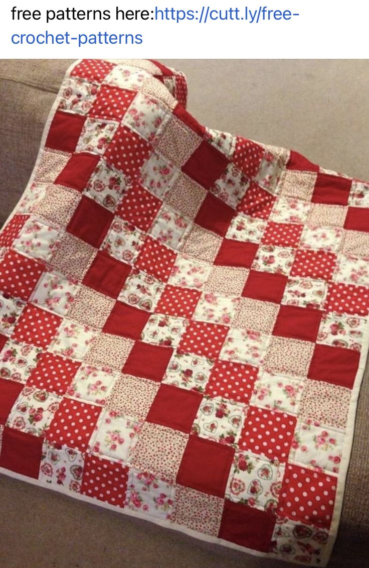 a red and white quilt sitting on top of a couch