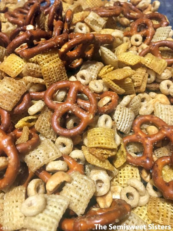 a pile of chex mix with pretzels and crackers in the middle