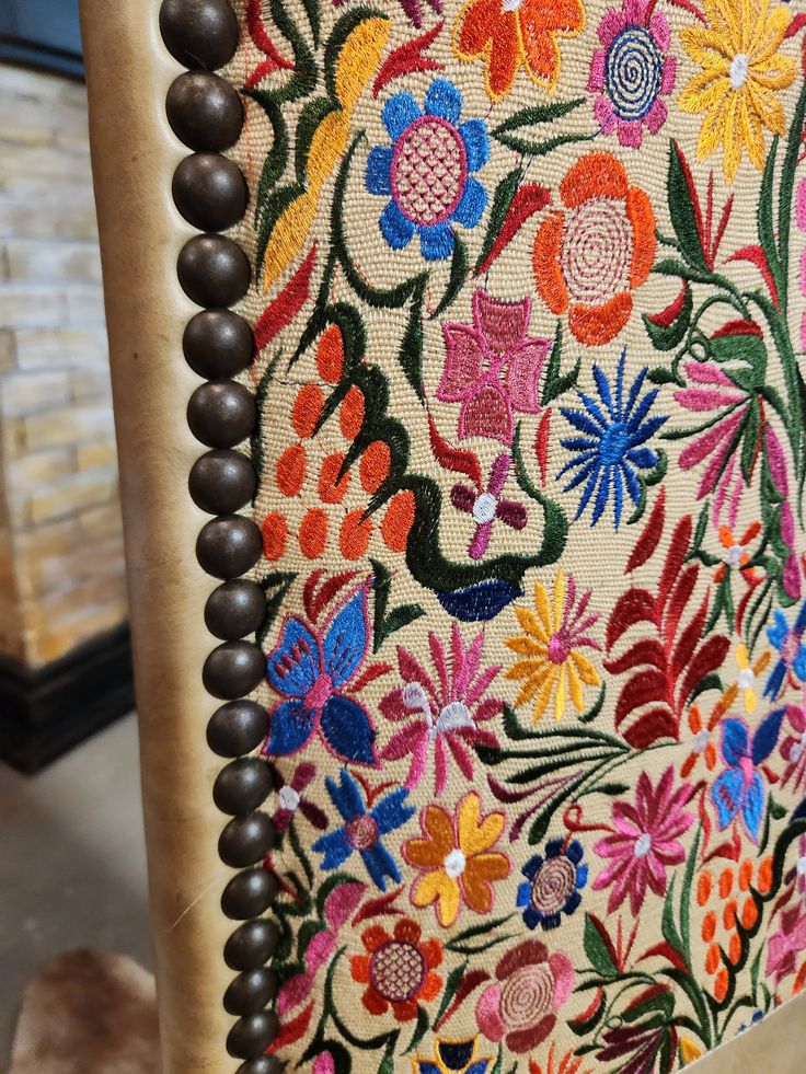 an upholstered chair with beading and flowers on it