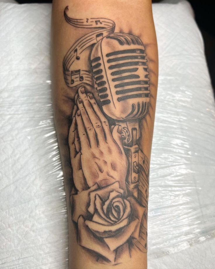 a tattoo with a microphone and roses on it