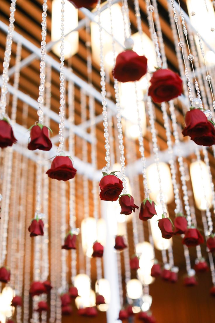 red roses are hanging from the ceiling with beads