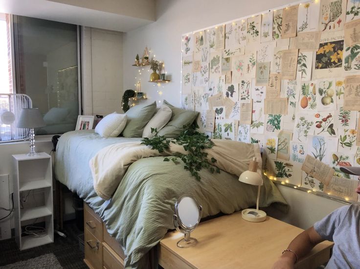 a woman sitting in front of a bed with lots of papers on the wall behind her