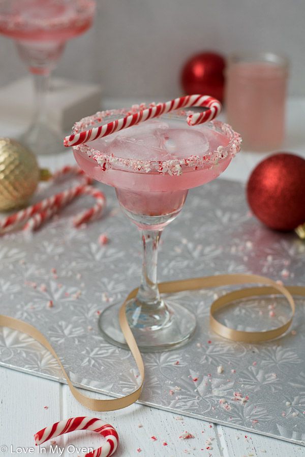 peppermint vodka cocktail in a coupe glass with candy canes