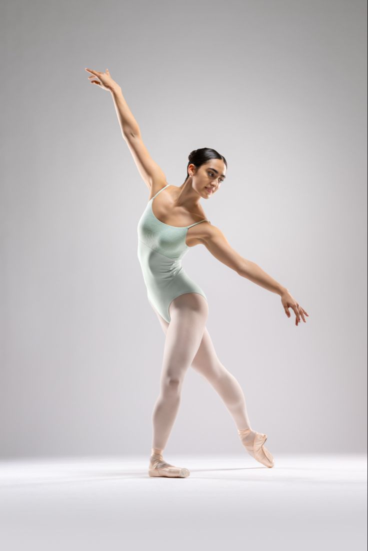 a young ballerina is posing for the camera