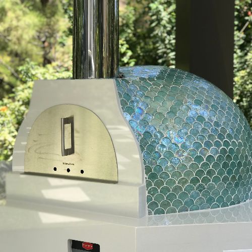 an outdoor pizza oven with blue and green tiles on it