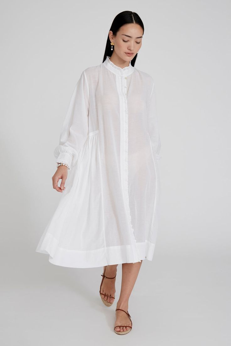 Cotton and viscose blend button down dress with ruffled details and balloon sleeves. 55% Cotton, 45% Viscose. 22.5" Bust, 23" Sleeve, 54.5" Bottom Width, 51" Total Length. One size: Fits sizes S-L. Machine wash cold. Made in India. Spring Daywear Puff Sleeve Dress With Bishop Sleeves, Spring Puff Sleeve Dress With Bishop Sleeves For Daywear, Voluminous Puff Sleeve Dress For Summer Daywear, Summer Long Sleeve Puff Dress With Pleated Sleeves, Chic Smock Dresses With Relaxed Fit, Relaxed Fit Ruffled Dresses For Daywear, Relaxed Fit Ruffle Dress For Daywear, Chic Billowy Midi Dress For Daywear, Chic Oversized Balloon Sleeve Dresses