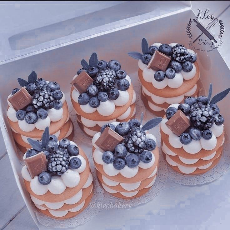 there are many small cakes that have blueberries on them in the shape of flowers