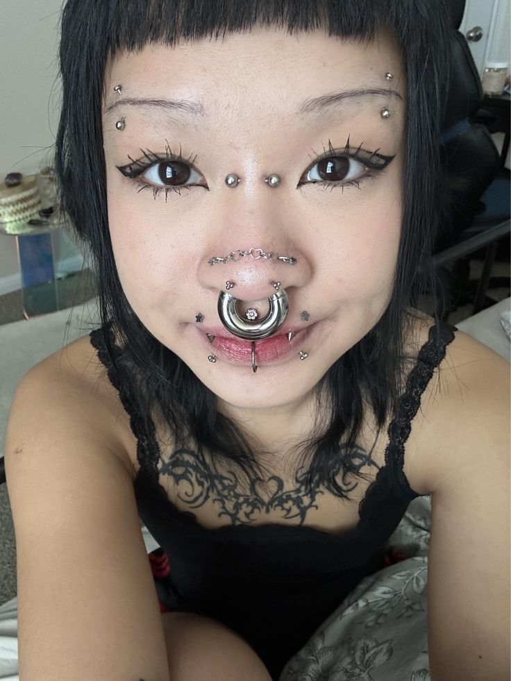 a woman with piercings on her nose and nose ring in front of her face