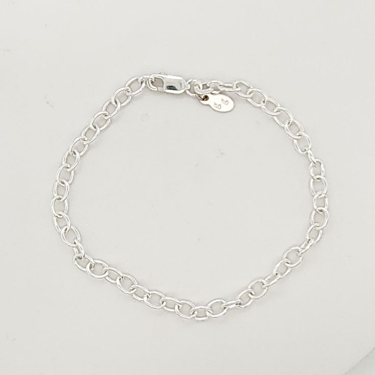 This Silver Charm Bracelet is a stylish and versatile accessory for women. Made of high-quality .925 sterling silver, this bracelet adds a touch of elegance to any outfit. With its simple yet eye-catching design, it is perfect for everyday wear or special occasions. Enhance your style with this must-have piece. The bracelet is 7" long, and charms are sold separately. Classic Silver Chain Bracelet For Everyday, Classic Everyday Silver Chain Charm Bracelet, Classic Silver Charm Bracelet For Everyday, Everyday Round Charm Bracelet Jubilee Style, Minimalist Silver Chain Bracelet With Sterling Clasp, Minimalist Chain Bracelet With Sterling Silver Clasp, Silver Minimalist Bracelet With Lobster Clasp, Minimalist Silver Bracelet With Lobster Clasp, Modern Silver Charm Bracelet For Everyday