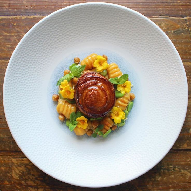 a white plate topped with macaroni and cheese on top of a wooden table