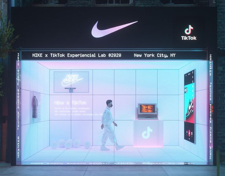 a man walking in front of a store window with the nike logo projected on it