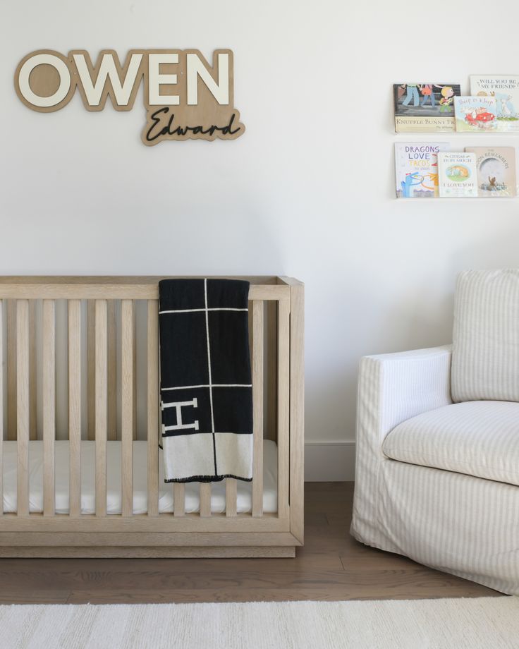 a baby's room with a crib, rocking chair and wall hangings