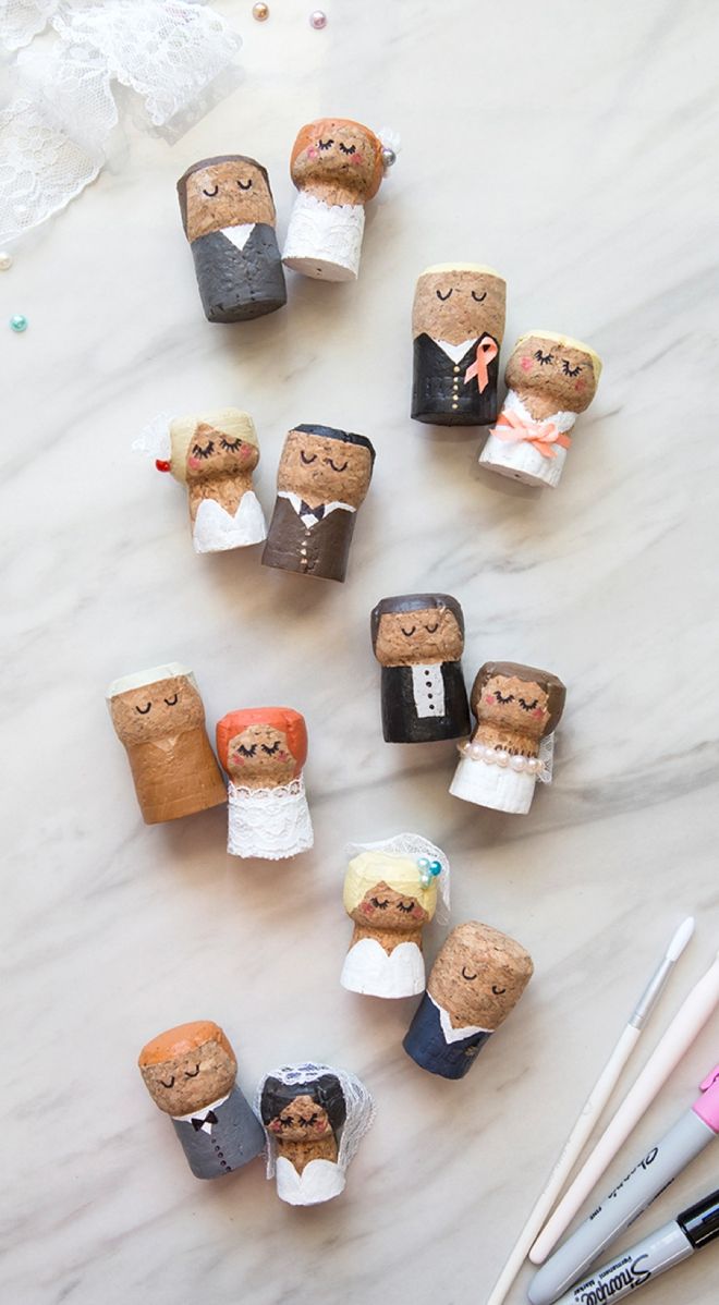 wedding cake toppers are arranged on a marble table with markers, pens and crayons