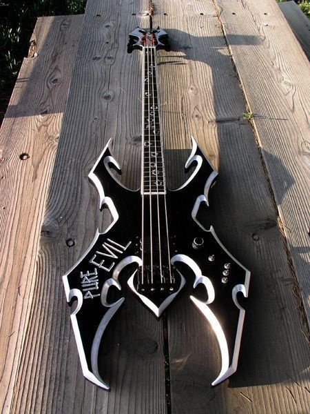 a black and white guitar sitting on top of a wooden table