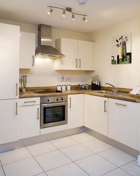 a kitchen with white cabinets and stainless steel appliance on the left side of the screen