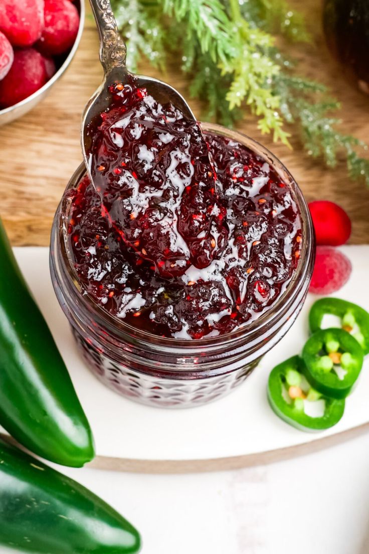 a spoon full of cranberry sauce next to peppers