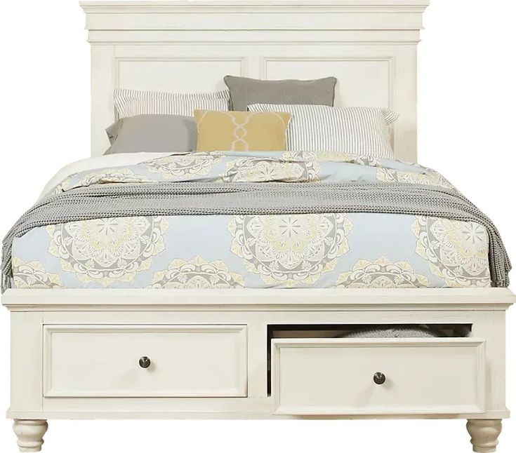 a white bed with two drawers underneath it and pillows on top of the headboard