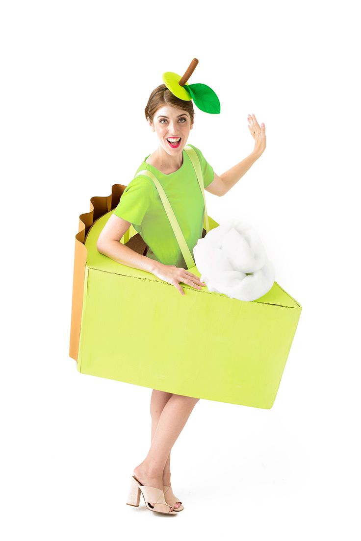 a woman in a green shirt and hat is holding a cardboard box with an apple on it