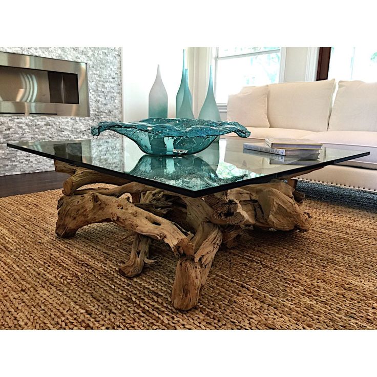 a glass table sitting on top of a rug in front of a living room couch