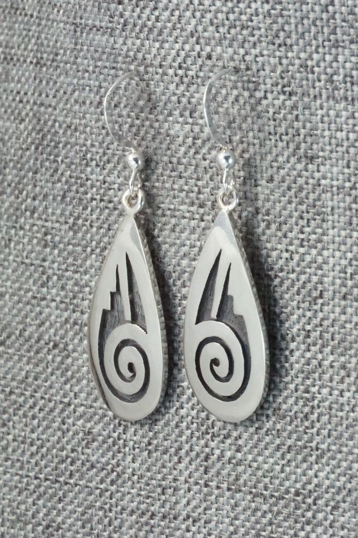 These sterling silver earrings are made by Hopi silversmith Timothy Mowa. The backs are signed and stamped sterling.Length: 1 5/8"Width: 1/2"Free shipping on all orders! We ship with USPS and always include tracking. All orders ship within a day of payment.Returns are accepted up to 30 days after you receive your order. Just send us a message. Our shop offers cash back or store credit. The item must be returned in new condition. Silver Southwestern Style Earrings For Gifting, Silver Southwestern Earrings For Gift, Silver Southwestern Style Earrings For Gift, Southwestern Silver Earrings For Gifts, Engraved Teardrop Sterling Silver Earrings, Symbolic Sterling Silver Pierced Earrings, Silver Engraved Teardrop Earrings, Silver Symbolic Engraved Earrings, Silver Engraved Symbolic Earrings