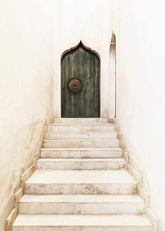 a set of stairs leading up to a door with a circular design on the front