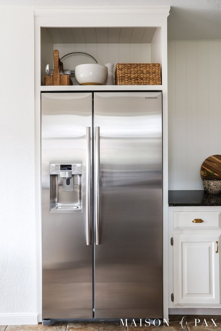 a stainless steel refrigerator in a white kitchen